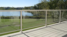 Residential glass aluminum railing photo with light clay modular aluminum decking and a view of a lake by Versadeck Decking